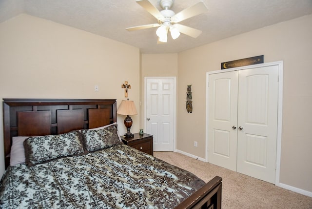 carpeted bedroom featuring ceiling fan and a closet