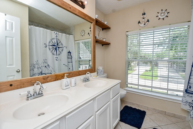 bathroom featuring tile patterned floors, plenty of natural light, toilet, and vanity