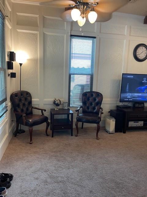 sitting room featuring ceiling fan and carpet