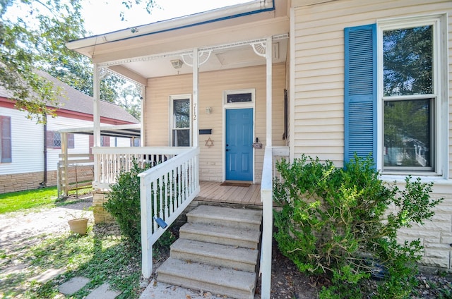 view of exterior entry featuring covered porch