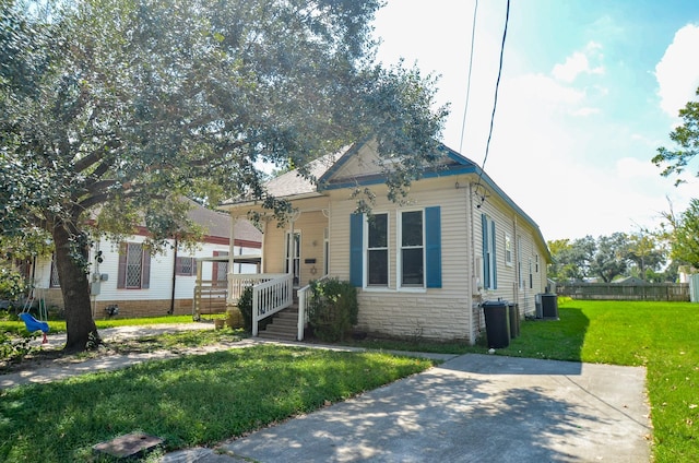 view of front facade with cooling unit and a front lawn