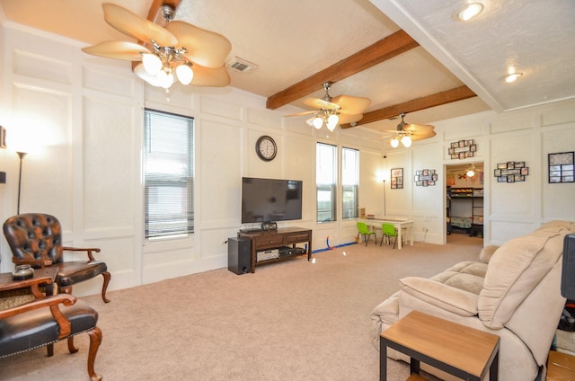 carpeted living room featuring beamed ceiling and a textured ceiling