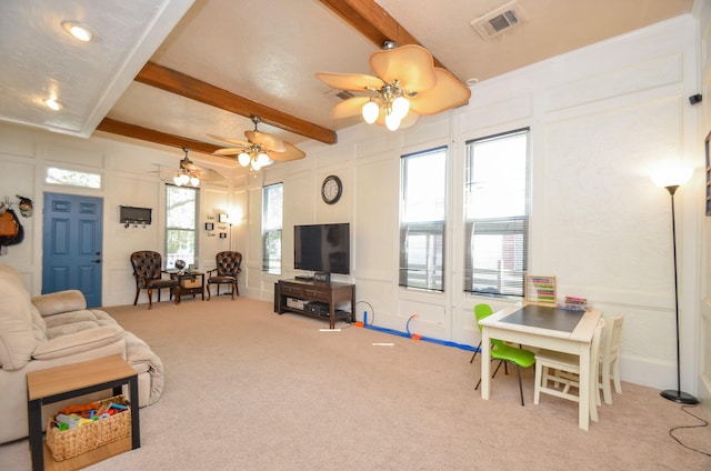 carpeted living room with beamed ceiling and ceiling fan