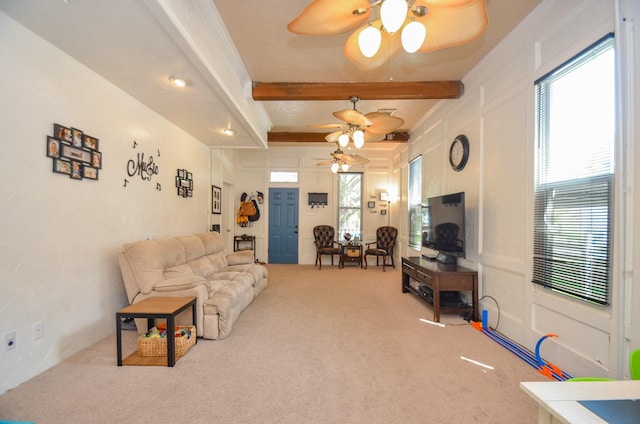 carpeted living room with beamed ceiling, ceiling fan, and a healthy amount of sunlight