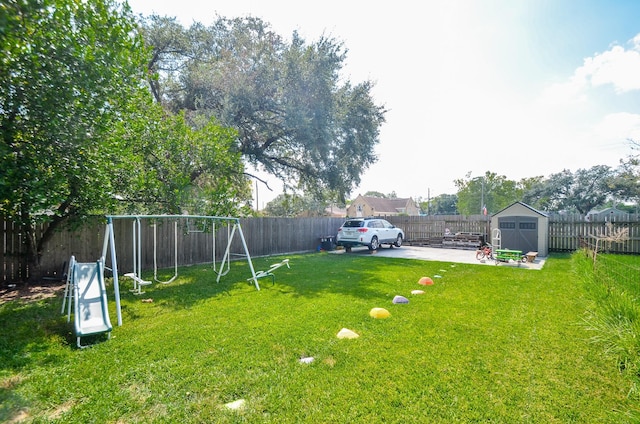 view of yard featuring a playground, a patio, and a shed