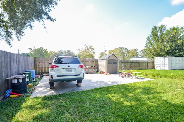 view of yard featuring a storage unit and a patio area