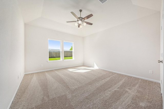 spare room featuring carpet flooring, a tray ceiling, and ceiling fan