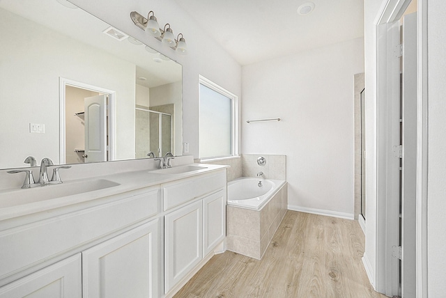 bathroom featuring vanity, separate shower and tub, and wood-type flooring