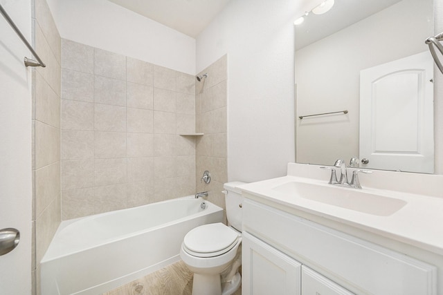 full bathroom with hardwood / wood-style flooring, tiled shower / bath combo, toilet, and vanity