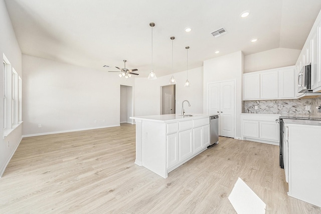 kitchen featuring pendant lighting, a kitchen island with sink, sink, ceiling fan, and white cabinetry