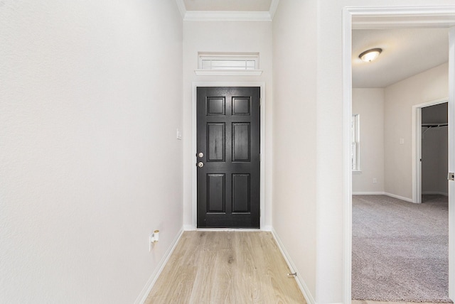 doorway to outside featuring crown molding and light wood-type flooring