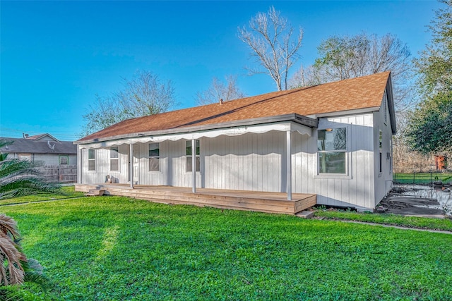 rear view of property with a lawn and a porch