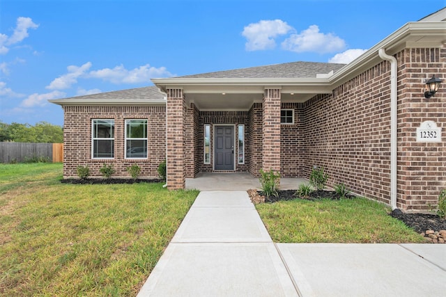 view of exterior entry with a lawn