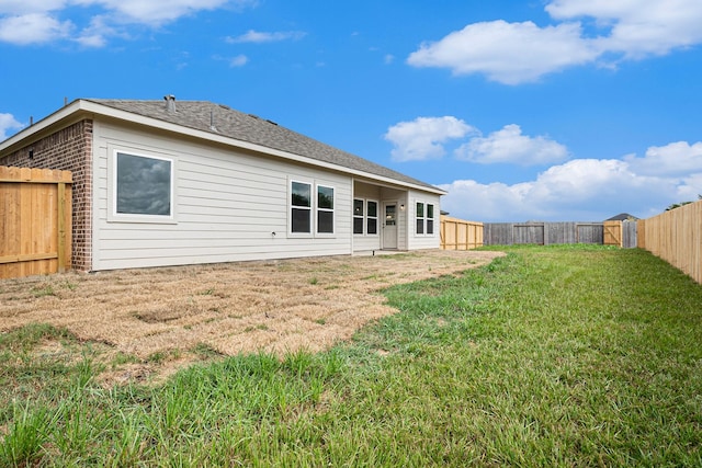 rear view of house with a yard