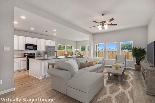 living room with ceiling fan and light hardwood / wood-style floors