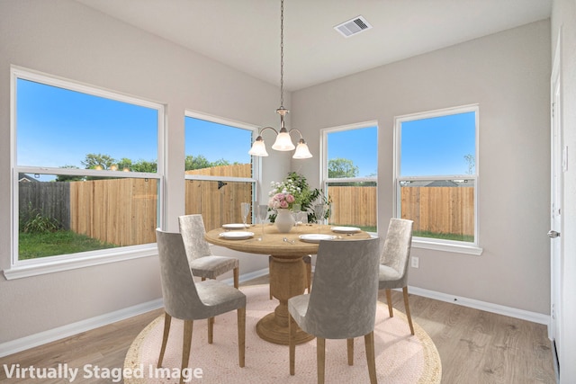 dining area with a chandelier and light wood-type flooring