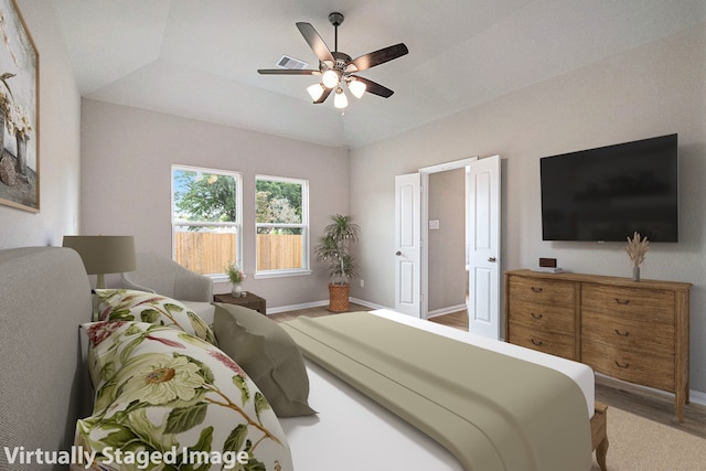 bedroom featuring ceiling fan, hardwood / wood-style floors, and vaulted ceiling