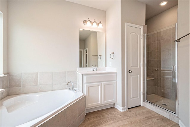 bathroom with vanity, wood-type flooring, and shower with separate bathtub