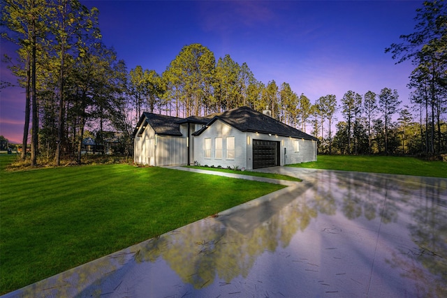 view of front of property with a garage and a yard