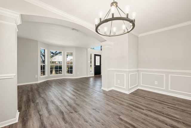 interior space featuring decorative columns, crown molding, dark hardwood / wood-style flooring, and a chandelier