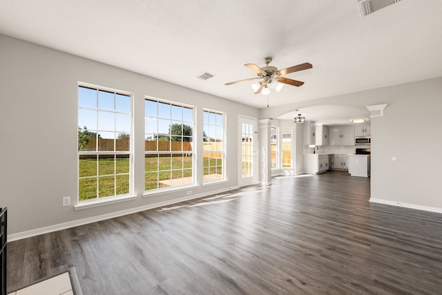 unfurnished living room featuring ceiling fan, sink, and dark wood-type flooring