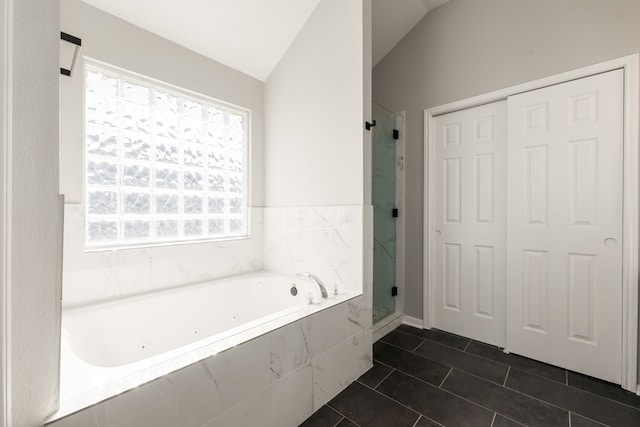 bathroom with tile patterned flooring, plus walk in shower, and vaulted ceiling