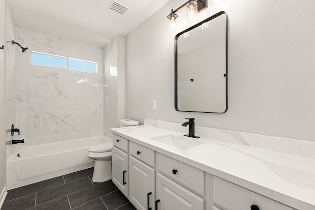 full bathroom featuring tile patterned flooring, toilet, vanity, and tiled shower / bath