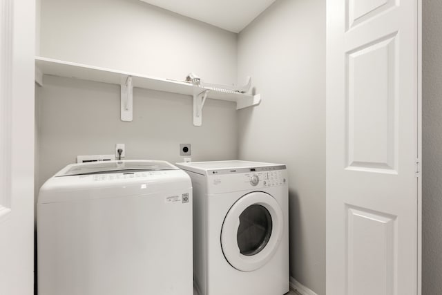 clothes washing area with washing machine and dryer