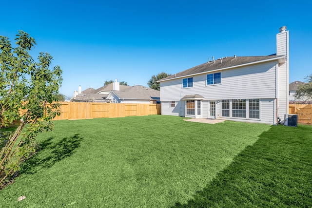 rear view of house with central air condition unit, a patio area, and a lawn