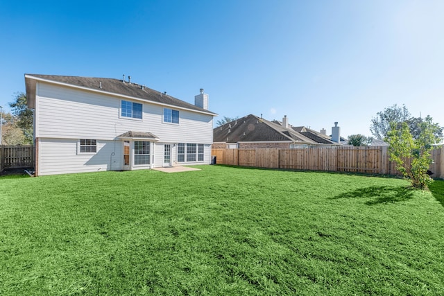 rear view of property with a yard