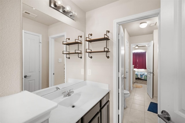 bathroom with toilet, vanity, and tile patterned floors