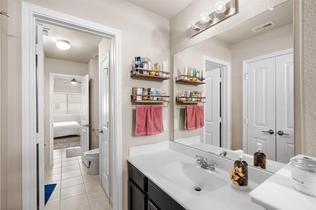 bathroom with tile patterned flooring, vanity, ceiling fan, and toilet