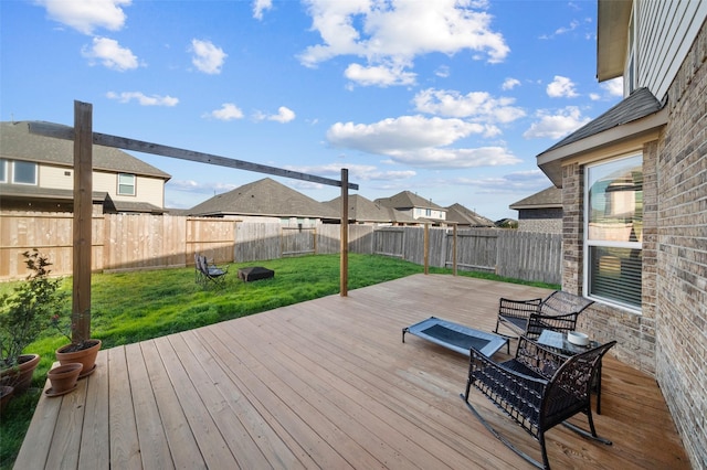 wooden terrace featuring a lawn