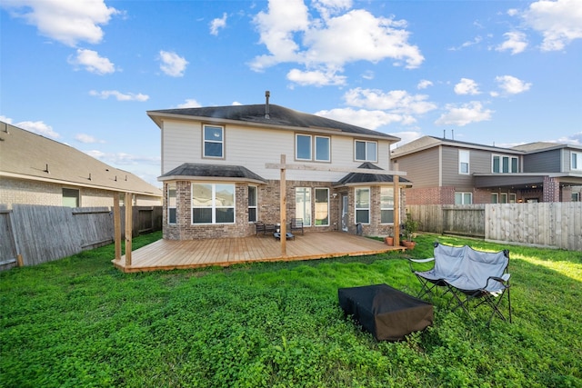 back of house featuring a lawn and a wooden deck