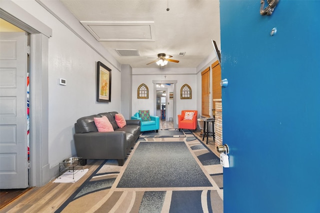 living room featuring ceiling fan, a textured ceiling, and hardwood / wood-style flooring