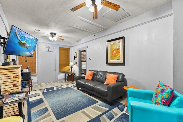 living room featuring a textured ceiling, hardwood / wood-style flooring, and ceiling fan