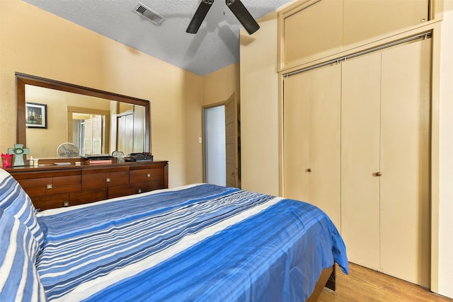 bedroom featuring ceiling fan, light hardwood / wood-style floors, and a textured ceiling