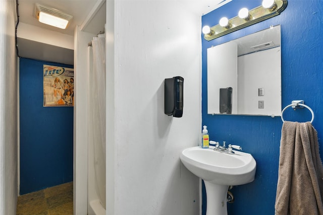 full bathroom featuring a shower with shower curtain and visible vents