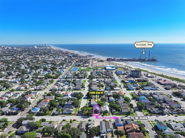 drone / aerial view with a water view, a residential view, and a beach view