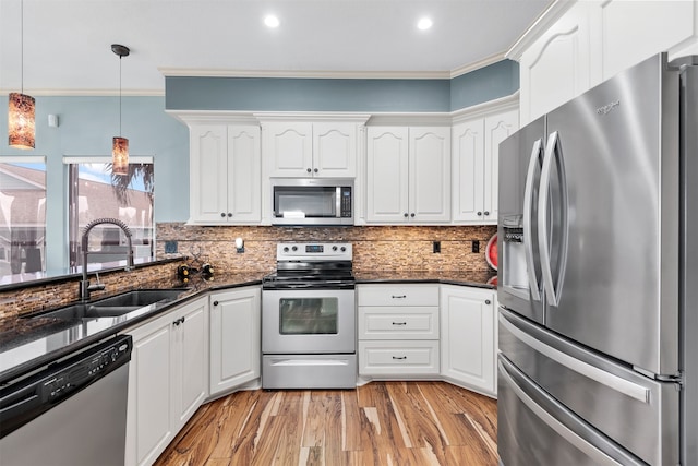 kitchen with pendant lighting, sink, white cabinetry, and stainless steel appliances