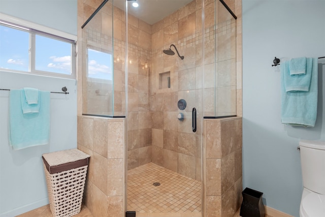 bathroom with toilet and a shower with shower door