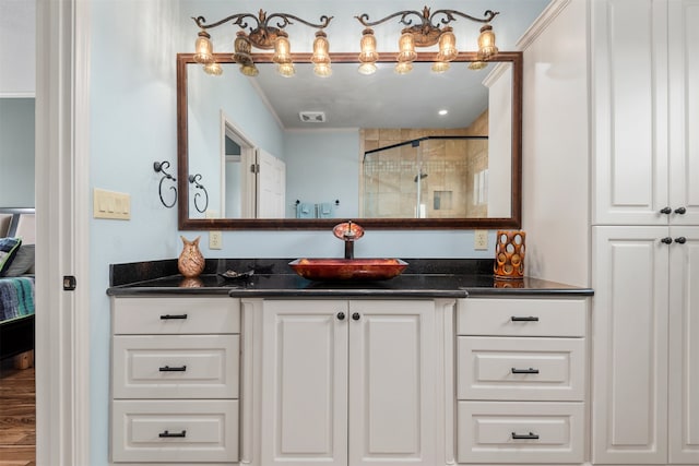 bathroom featuring vanity, crown molding, and walk in shower