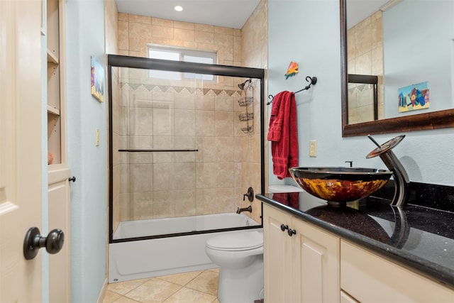 full bathroom with tile patterned floors, vanity, toilet, and bath / shower combo with glass door