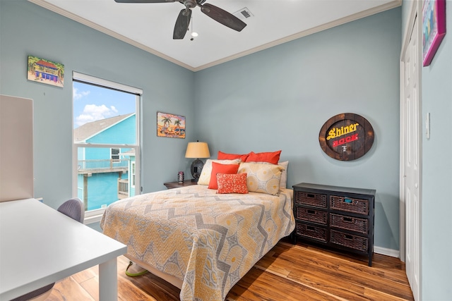 bedroom with hardwood / wood-style flooring, ceiling fan, and ornamental molding