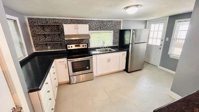 kitchen featuring a wealth of natural light, sink, white cabinets, and stainless steel appliances