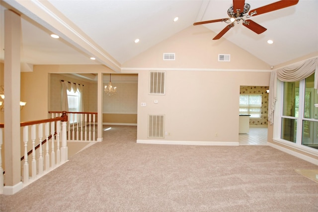 unfurnished room with ceiling fan with notable chandelier, light colored carpet, and high vaulted ceiling