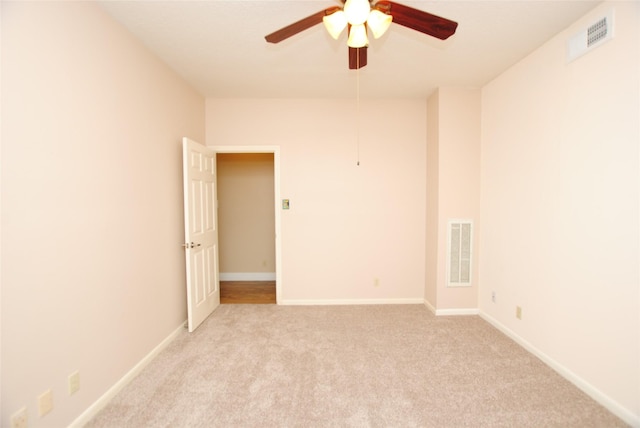 spare room with light colored carpet and ceiling fan