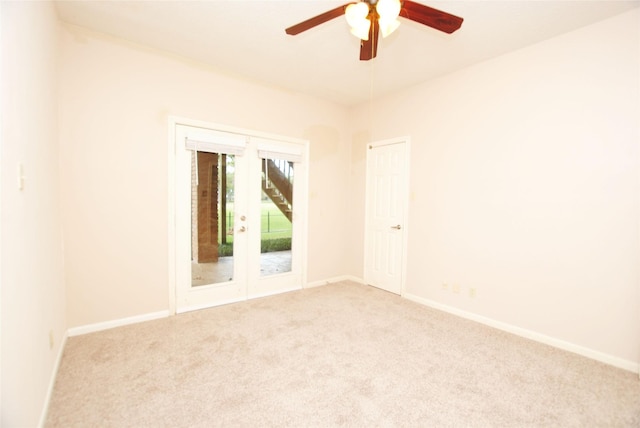 carpeted spare room with ceiling fan and french doors