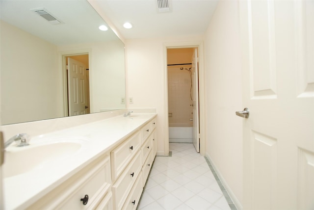 bathroom featuring tiled shower / bath combo, vanity, and tile patterned flooring