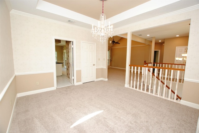 unfurnished room with ceiling fan with notable chandelier, ornamental molding, a raised ceiling, and carpet